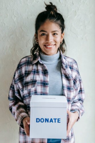 a woman holding a donation box